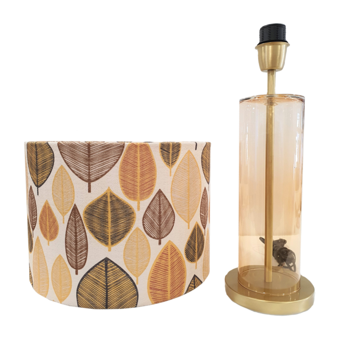 Table lamp with cylindrical base in golden transparent glass and cylindrical lamp shade with brown, bege, green leaves