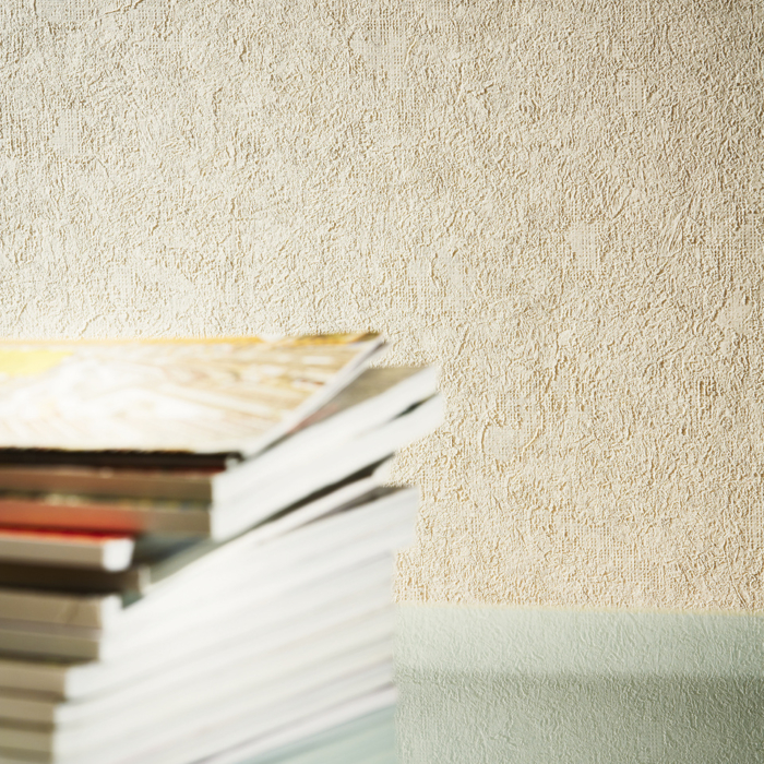 Beige embossed wallpaper and books on the table