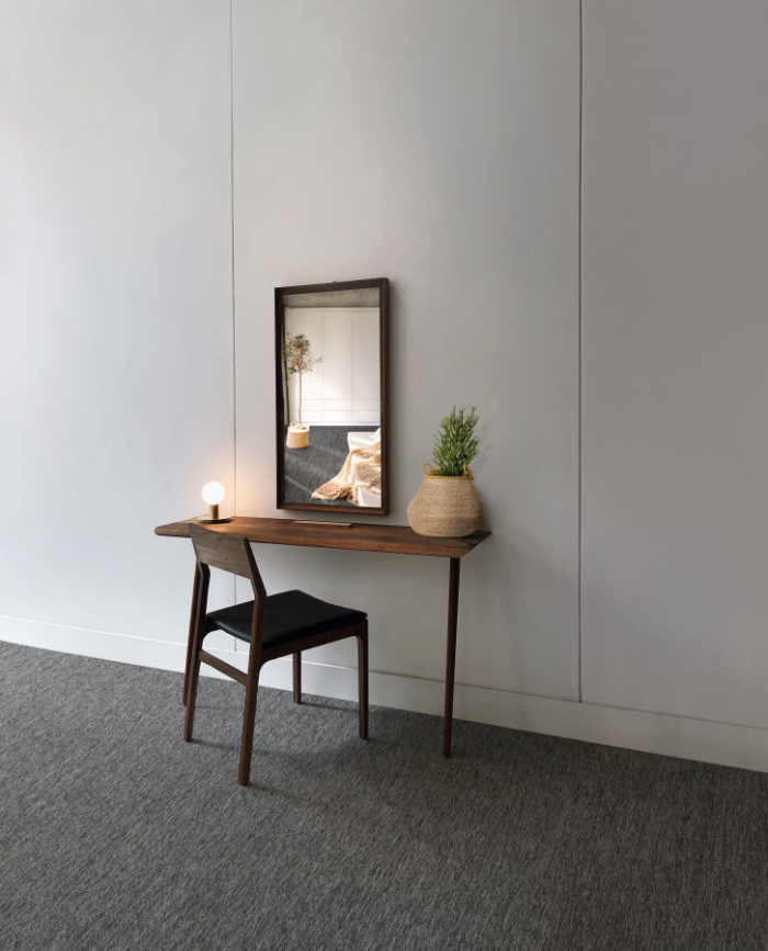 Bedroom with sisal carpet in dark tones, desk, mirror and chair