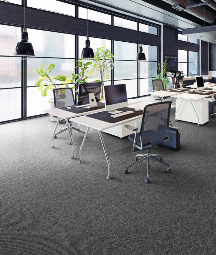 Office with dark sisal carpet, tables, chairs and computers