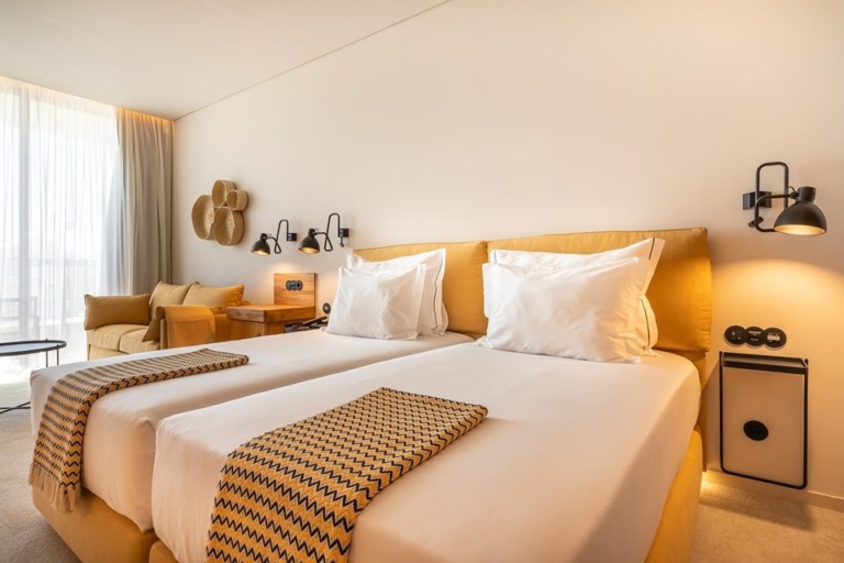 Bedroom with two beds, bed headboard and base in toasted yellow, foot covers over the mattresses