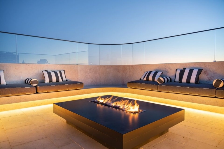 Rooftop with coxin and decorative cushions and coffee table with flame